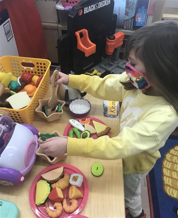 Preschooler  Julianna Torr plays with food
